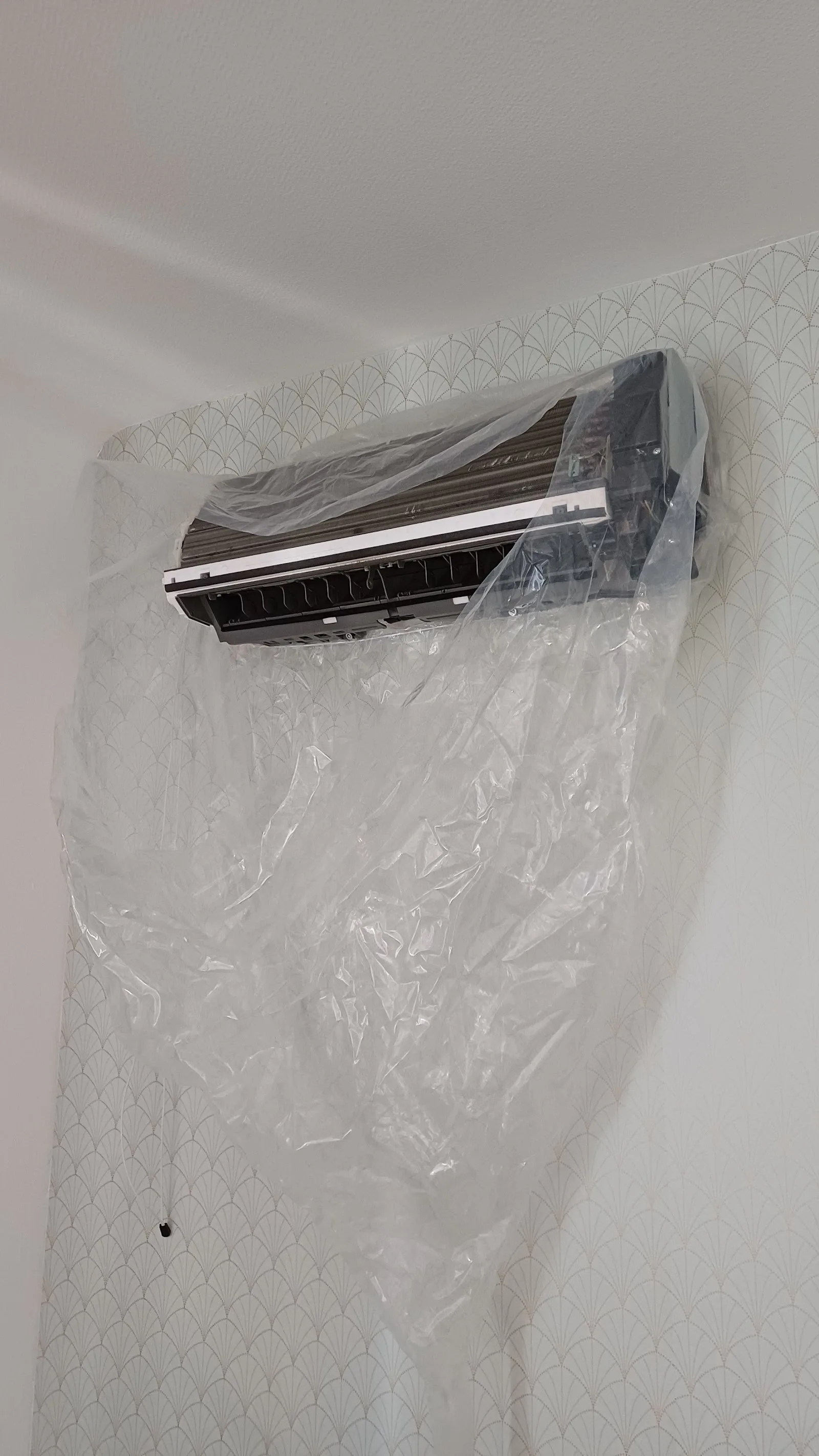 Pompe à chaleur air-air installée le long d'un mur, côté jardin