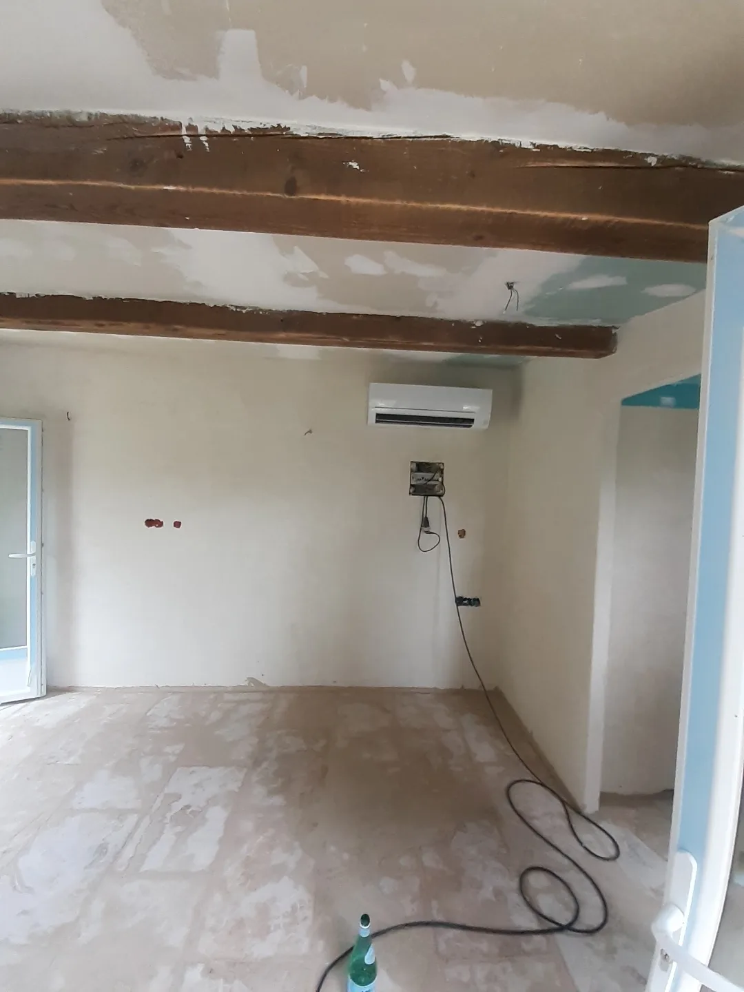 Split mural blanc posé au-dessus d'un mur en pierre reconstituée, à l'intérieur d'un logement
